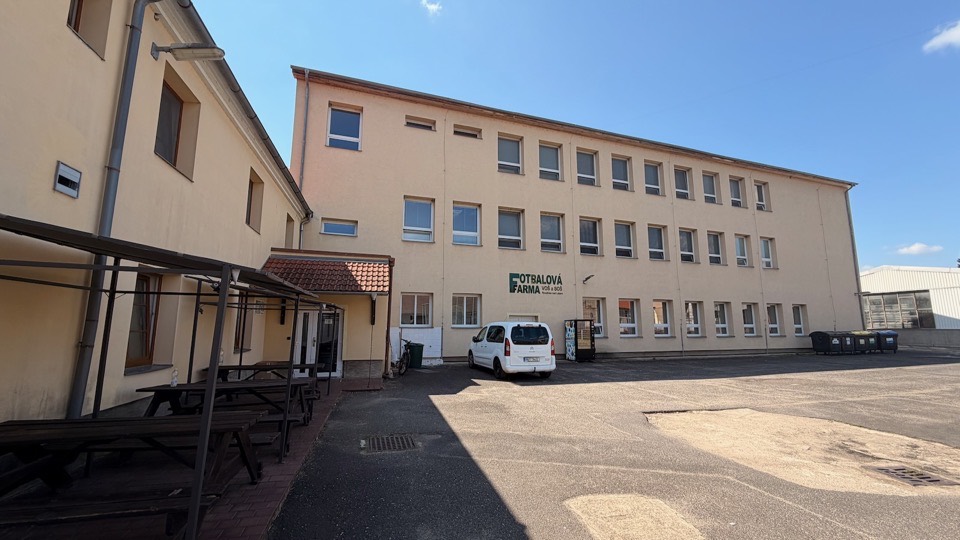 Pohled do dvora areálu s hřištěm v pozadí