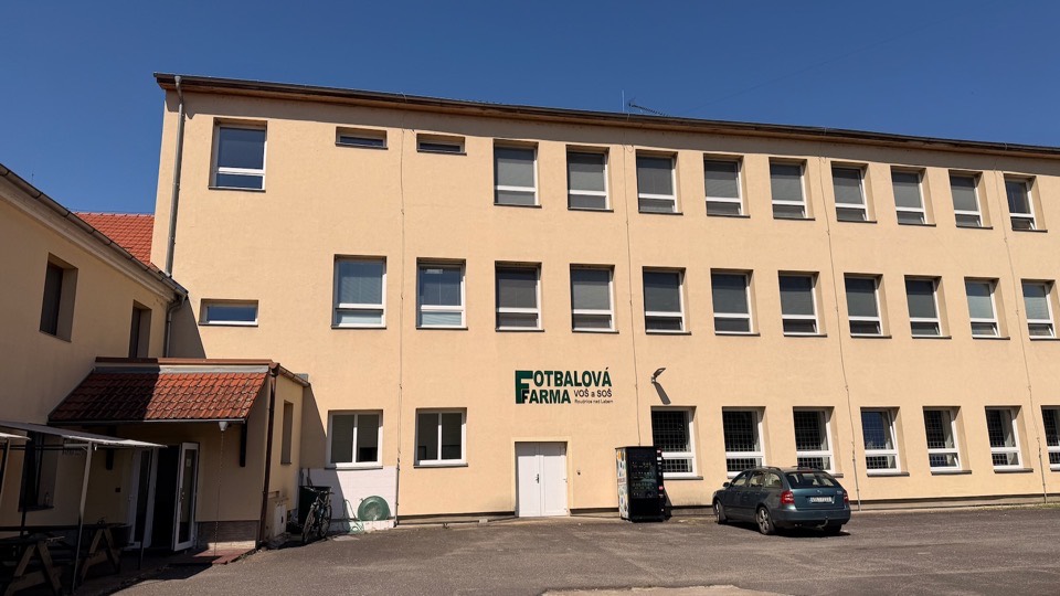 Nová budova ubytovny se třemi podlažími a logem Fotbalová farma VOŠ a SOŠ na fasádě